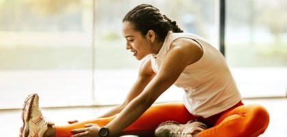 A woman enjoying a yoga stretch indoors, promoting a healthy lifestyle.