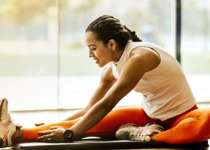 A woman enjoying a yoga stretch indoors, promoting a healthy lifestyle.